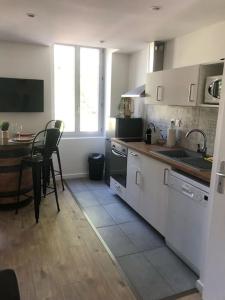 une cuisine avec un évier et une table avec des chaises dans l'établissement Appartement Vignes Vienne nord, à Vienne