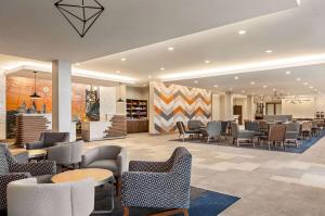 劳雷尔山La Quinta Inn & Suites by Wyndham Mount Laurel Moorestown的一个带桌椅的餐厅和一个大堂