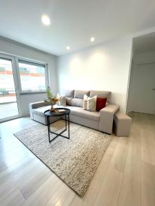 ein Wohnzimmer mit einem Sofa und einem Tisch in der Unterkunft Modern Spacious Apartment in Entroncamento