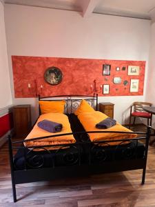 um quarto com uma cama preta e almofadas laranja em Pension Jeske Heidelberg em Heidelberg