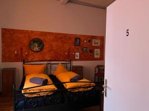 um quarto com uma cama com almofadas laranja em Pension Jeske Heidelberg em Heidelberg