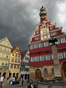 un grand bâtiment rouge avec une tour d'horloge sur lui dans l'établissement nah zur S-Bahn und Altstadt, à Esslingen am Neckar