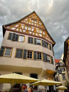 un grand bâtiment avec des parasols en face de celui-ci dans l'établissement nah zur S-Bahn und Altstadt, à Esslingen am Neckar