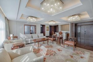 a living room with white furniture and a dining room at Sheraton Changsha Hotel in Changsha