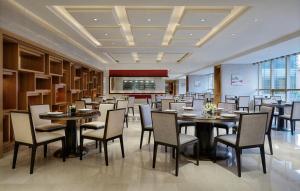 a restaurant with tables and chairs in a room at Sheraton Changsha Hotel in Changsha