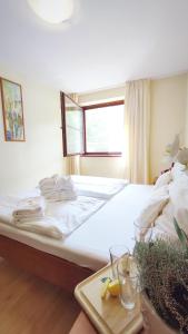 a bedroom with a large white bed with a table at Hotel Ambra in Luhačovice