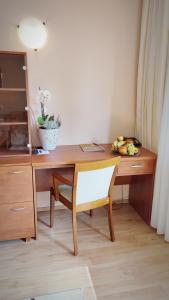 a wooden desk with a chair and a bowl of fruit at Hotel Ambra in Luhačovice