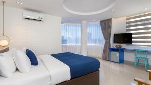 1 dormitorio con 1 cama grande y TV en Lucia Beach Hotel, en Da Nang