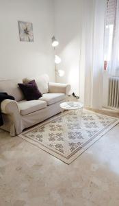 a living room with a white couch and a glass table at Casa Pallamaio Historic Center Vicenza in Vicenza