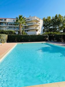 une grande piscine en face d'un bâtiment dans l'établissement Studio de standing climatisé, avec piscine, proche de la mer, à Fréjus