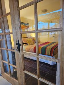 Cette chambre dispose d'un lit et d'une porte en verre. dans l'établissement Anka Lodge Quitor, à San Pedro de Atacama