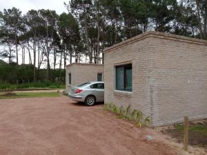 een auto geparkeerd op een parkeerplaats naast een bakstenen gebouw bij NEco apartamentos Naturistas Nudistas Parejas o mujeres solas in Punta del Este