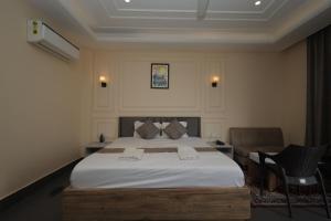 una camera con letto e sedia di Parth King Beach Resort a Mandarmoni