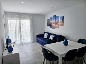 sala de estar con sofá azul y mesa en Apartment Dona Vitória - Monte Gordo Beach, en Monte Gordo