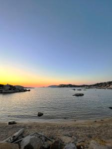 un tramonto su un corpo d'acqua con rocce di Affittimoderni La Maddalena - MADA18 a La Maddalena