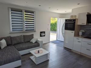 a living room with a couch and a kitchen at Pension Haus Leni am Schwanenteich in Mühlhausen