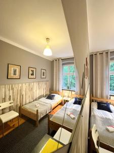 Explorer Hostel & Apartment Stare Miasto OLD TOWN 24H #don't be a tourist, be an Explorer! في بوزنان: غرفه فندقيه ثلاث اسره ونافذه