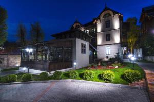 a large white building with lights in the night at Villa Mozart in Truskavets