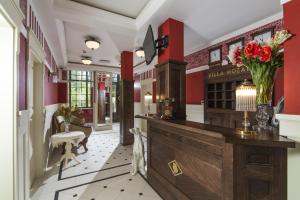 a lobby with red walls and a counter with a vase of flowers at Villa Mozart in Truskavets