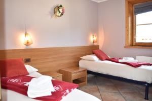 a room with two beds with red and white towels at Appartamento Trela 2 in Livigno