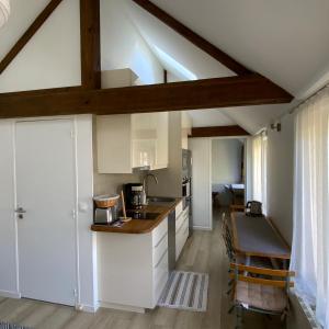 een keuken met witte kasten en een houten plafond bij La Maisonnette de Senlis in Senlis