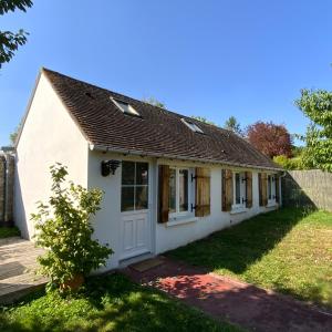 een klein wit huis met een tuin bij La Maisonnette de Senlis in Senlis