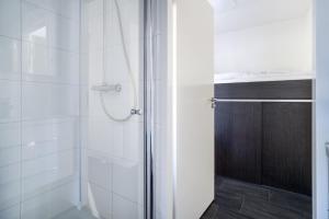 La salle de bains est pourvue d'une douche avec une porte en verre. dans l'établissement Holiday Home Maridu Family L-Cube, à Arnhem