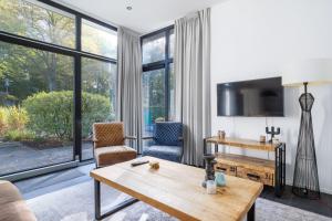 - un salon avec une table, des chaises et une télévision dans l'établissement Holiday Home Maridu Family L-Cube, à Arnhem