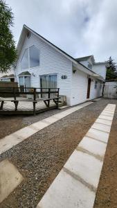 a white house with a bench in front of it at Casas Isla Negra in El Quisco