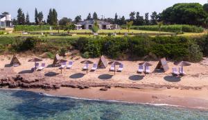 un grupo de sillas y sombrillas en una playa en TheLuxuryVillas, en Preveza