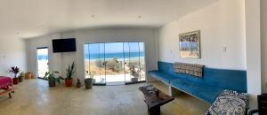 a living room with a blue couch and a view of the ocean at Tayta Surf House in Lobitos