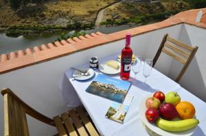 un tavolo con una bottiglia di vino e un piatto di frutta di Casa do Funil a Mértola