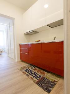 a kitchen with red cabinets and a rug on the floor at Le Dimore del Conte in Vicenza