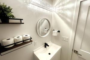 bagno bianco con lavandino e specchio di Exquisite, bright & modern condo. a Niagara Falls