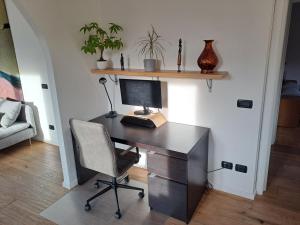 a desk with a computer and a chair in a room at Aosta Stunning Panoramic Views From Modern Two Bedroom Apartment in Aosta