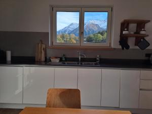 a kitchen with a sink and a window with a mountain at Aosta Stunning Panoramic Views From Modern Two Bedroom Apartment in Aosta