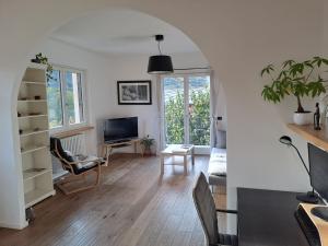 a living room with a table and chairs and a tv at Aosta Stunning Panoramic Views From Modern Two Bedroom Apartment in Aosta