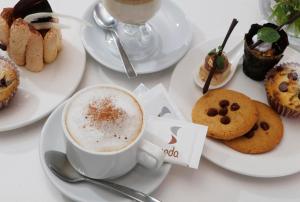 een tafel met gebakjes en een kopje koffie bij Seda Atria in Iloilo City