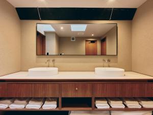 a bathroom with two sinks and a large mirror at illi Com Shimokitazawa in Tokyo