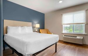 - une chambre avec un grand lit et une fenêtre dans l'établissement Extended Stay America Suites - St Paul - Woodbury, à Woodbury