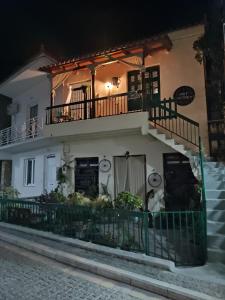 a white house with a balcony and stairs at Art apartment in Ancient Epidavros