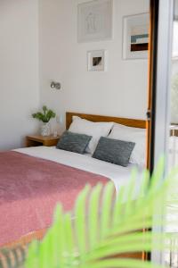 ein Schlafzimmer mit einem Bett mit zwei Kissen darauf in der Unterkunft Jasmine Hotel in São Pedro de Alva