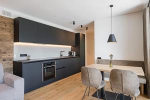 een keuken en eetkamer met een tafel en stoelen bij Apartsuites Rosengarten - New in Lagundo