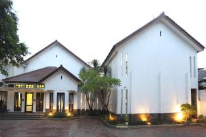 een groot wit huis met verlichting bij Jambuluwuk Residence Menteng in Jakarta