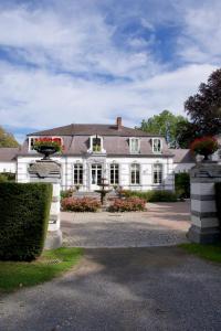 uma grande casa branca com caixas de flores numa entrada em Les Hys de Verdenne em Marche-en-Famenne