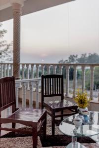 2 stoelen en een tafel op een balkon bij Silver Galaxy Resort in Panchgani