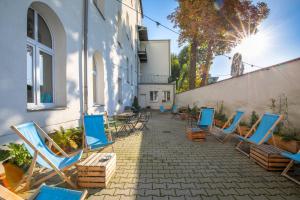 a group of chairs sitting on a patio next to a building at Atlantis Hostel in Kraków