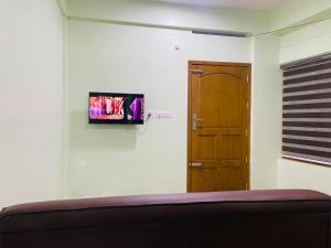 een kamer met een bed en een televisie aan de muur bij AL-Kabeer Lavender budget rooms in Trivandrum