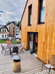 - une terrasse en bois avec des chaises et une table dans l'établissement Harrachov 702, à Harrachov