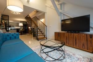 a living room with a blue couch and a tv at Apartment on the Main Street with Parking Old Town in Košice